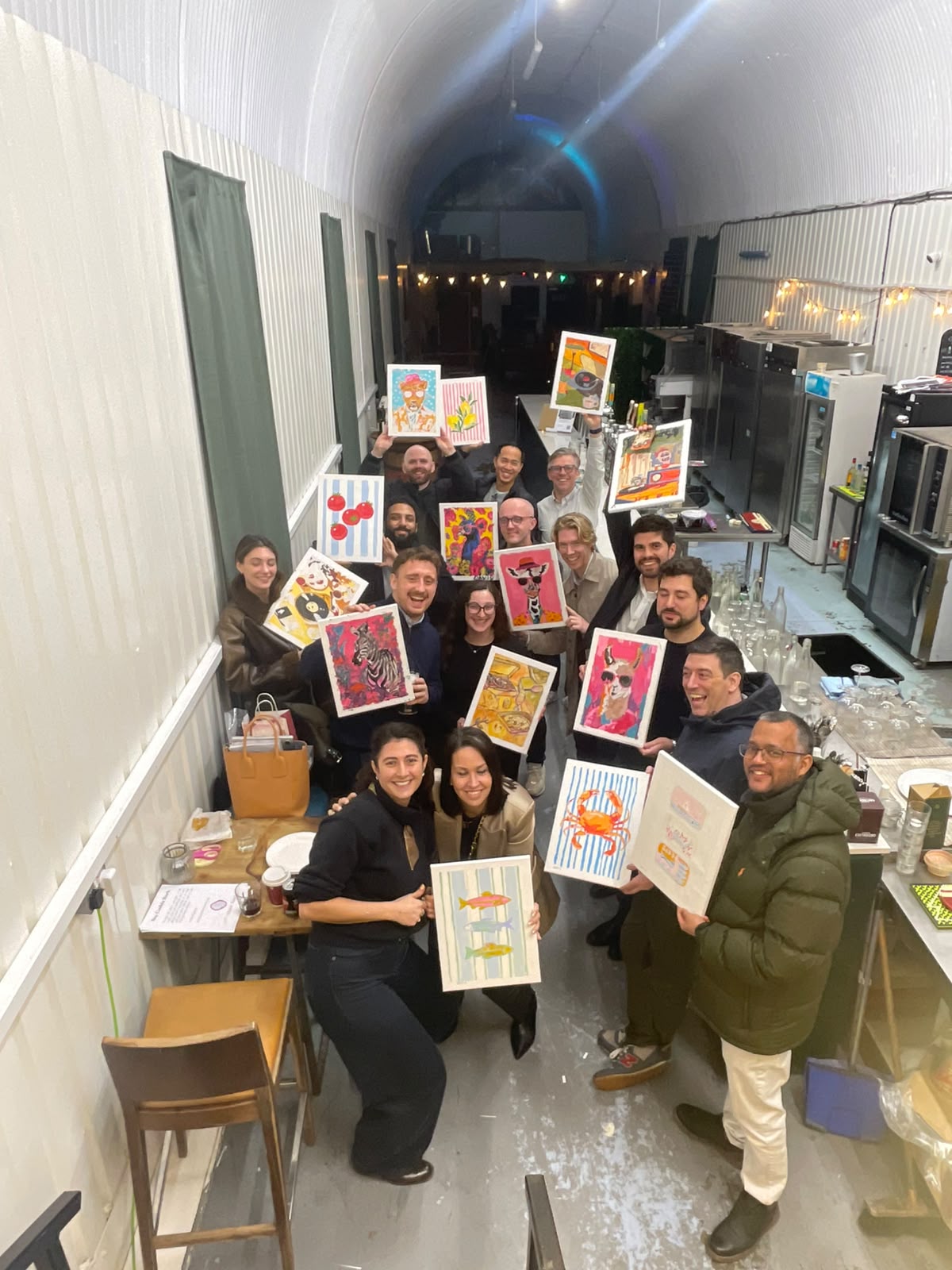 Grupo de colaboradores mostrando sus pinturas en un taller de team building de Latin Hands