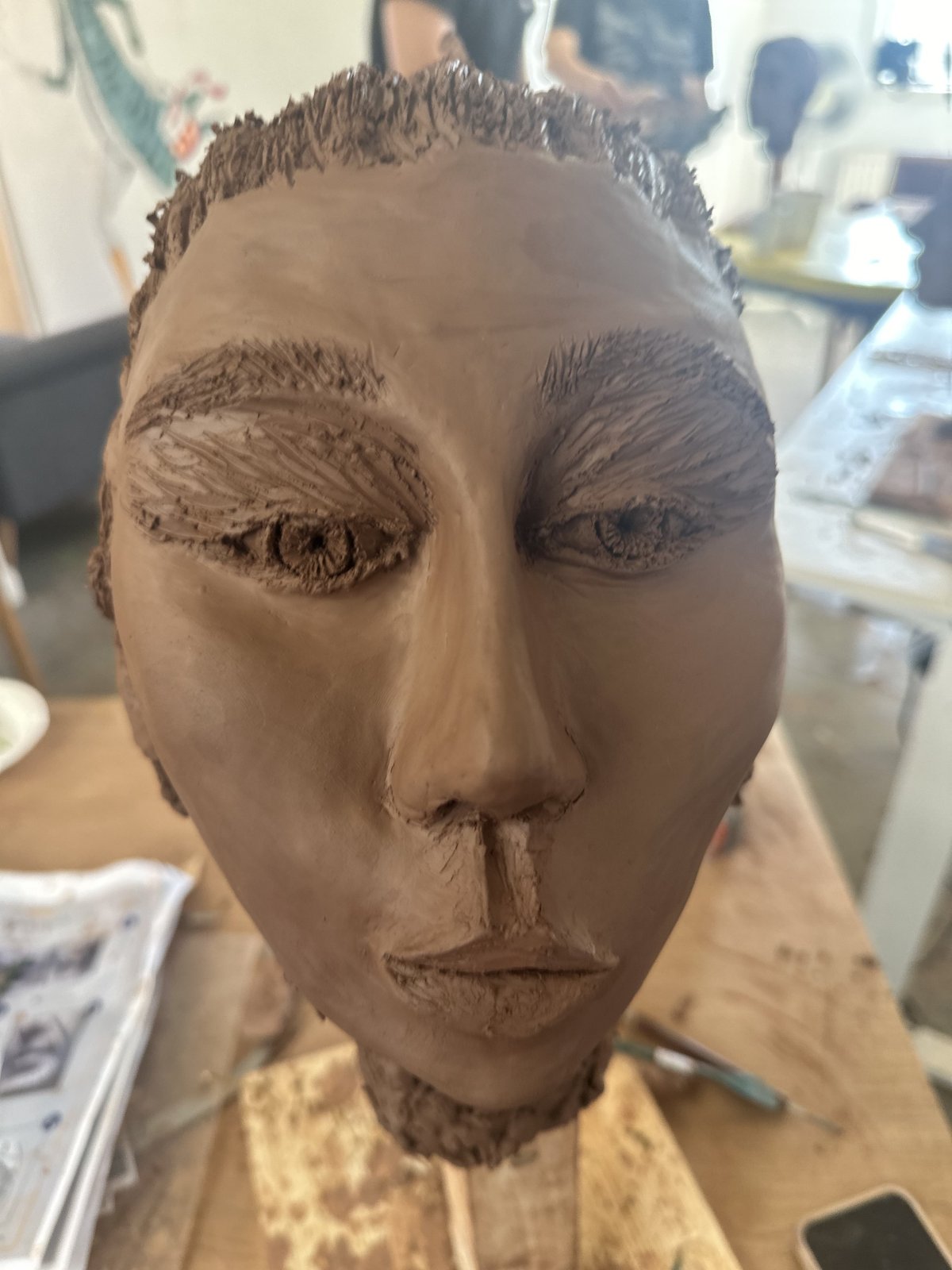 Escultura de un rostro humano modelada en arcilla