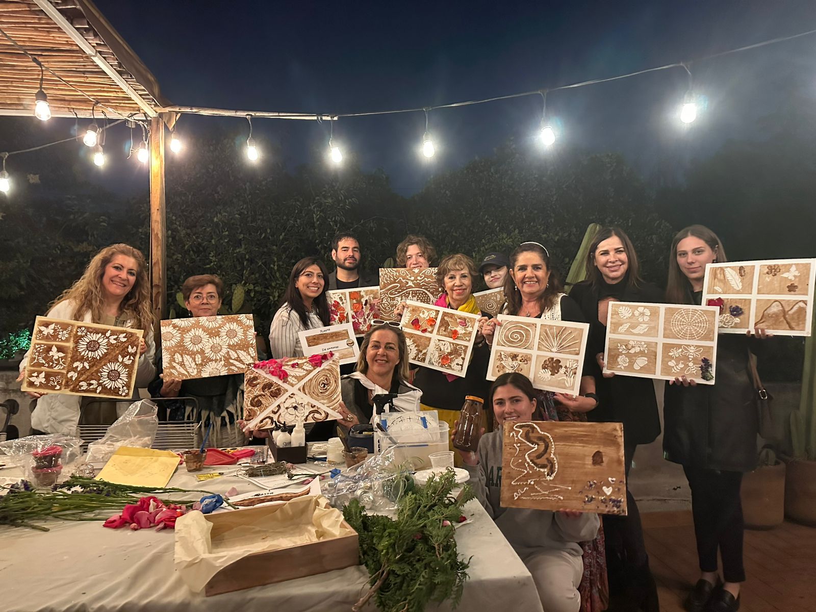 Grupo de participantes mostrando sus obras en un taller nocturno de Latin Hands